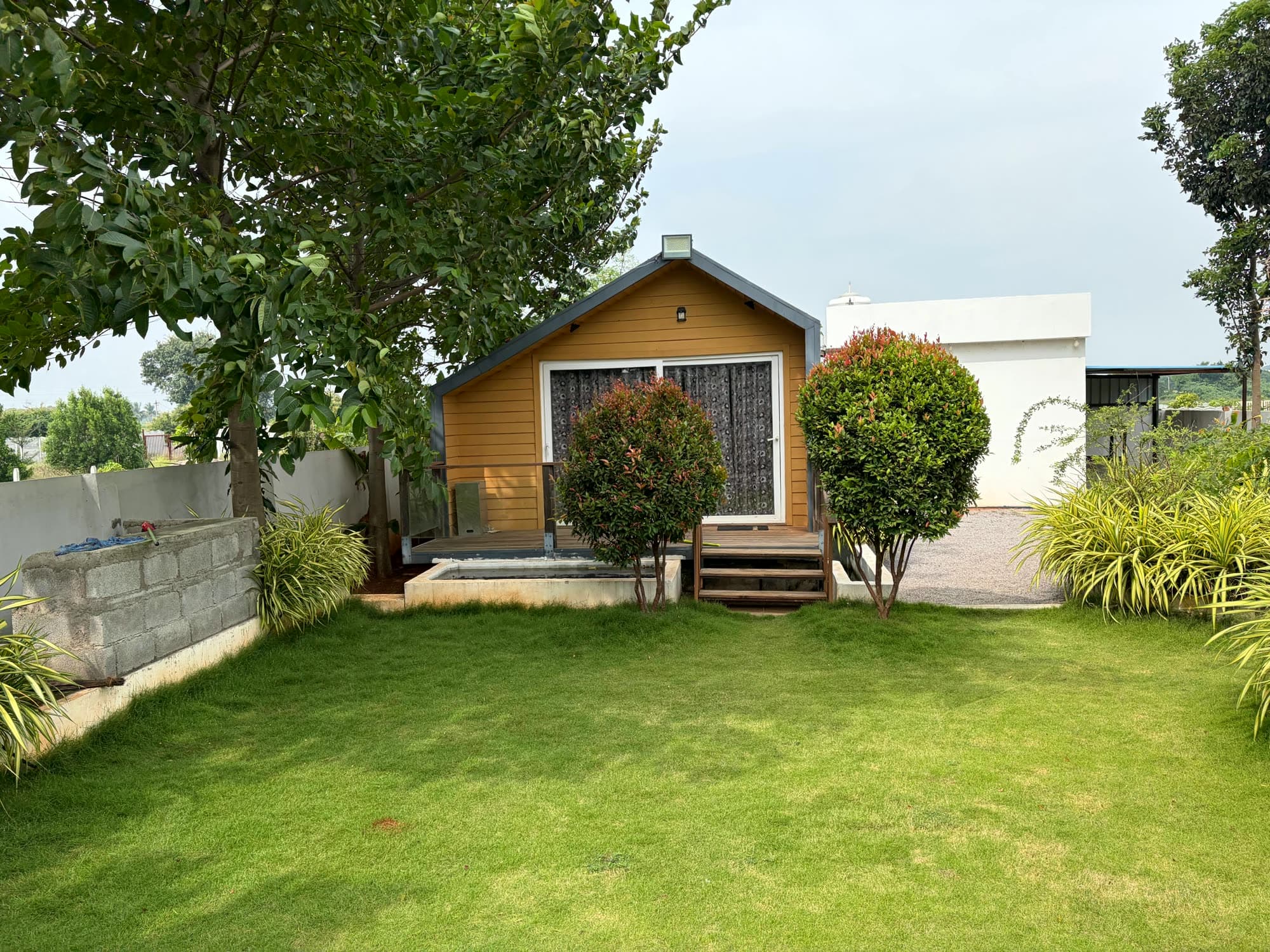The wooden cottage seen across the lawn